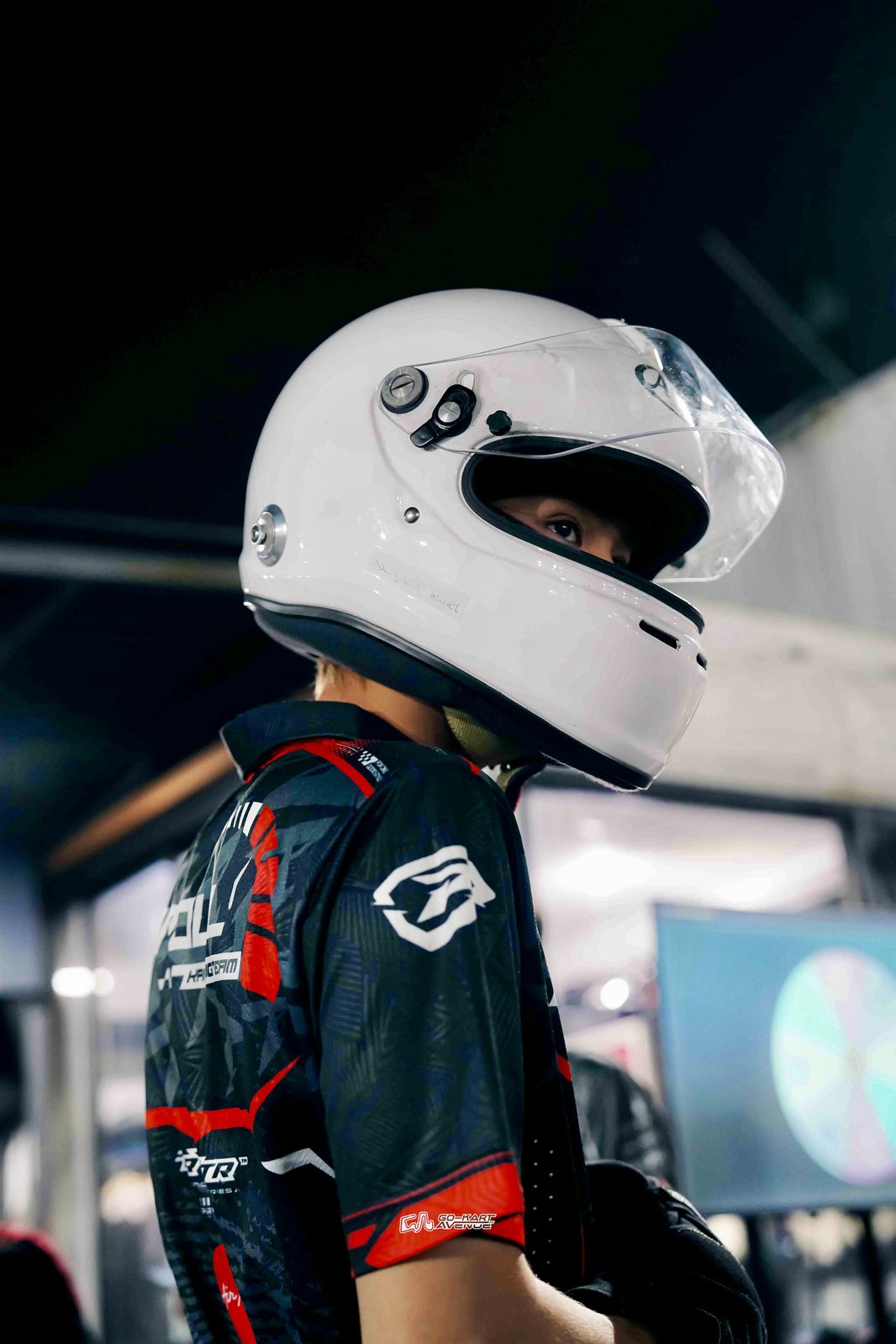 Faith Joshua Tzu in racing suit and helmet at Gokart Avenue pit lane