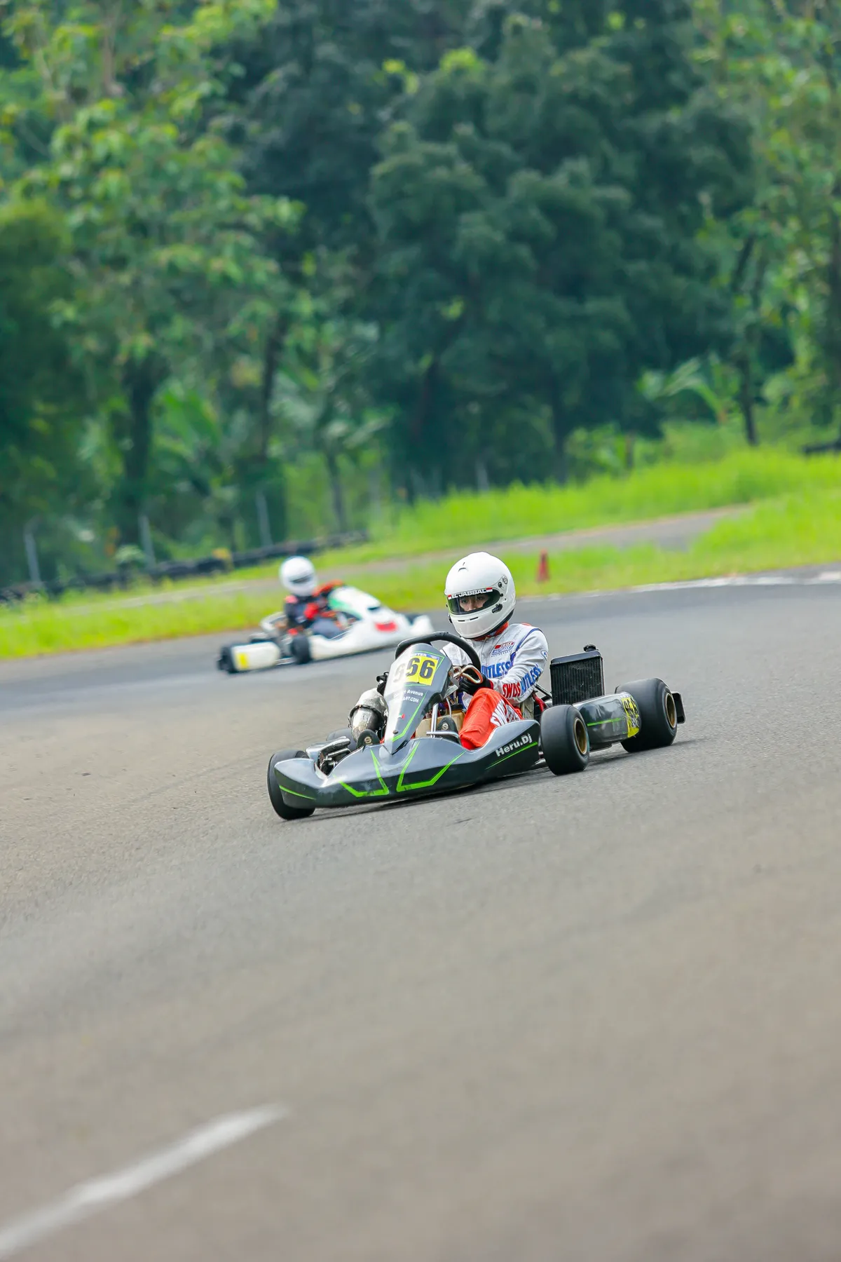Kart 566 racing through a corner, trailing kart in background