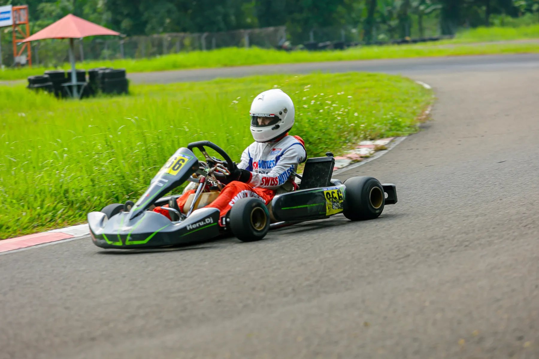 Kart racing on an outdoor grass-lined circuit
