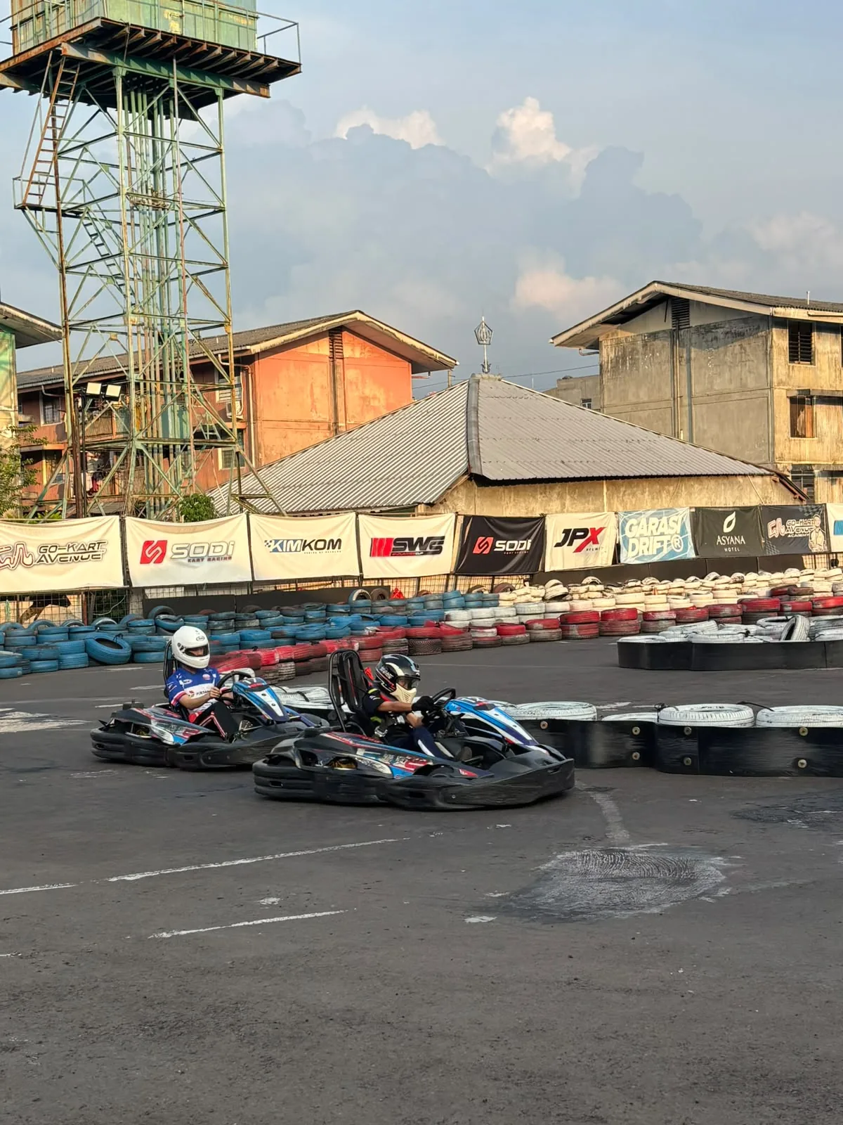 Two karts racing side by side on an outdoor circuit