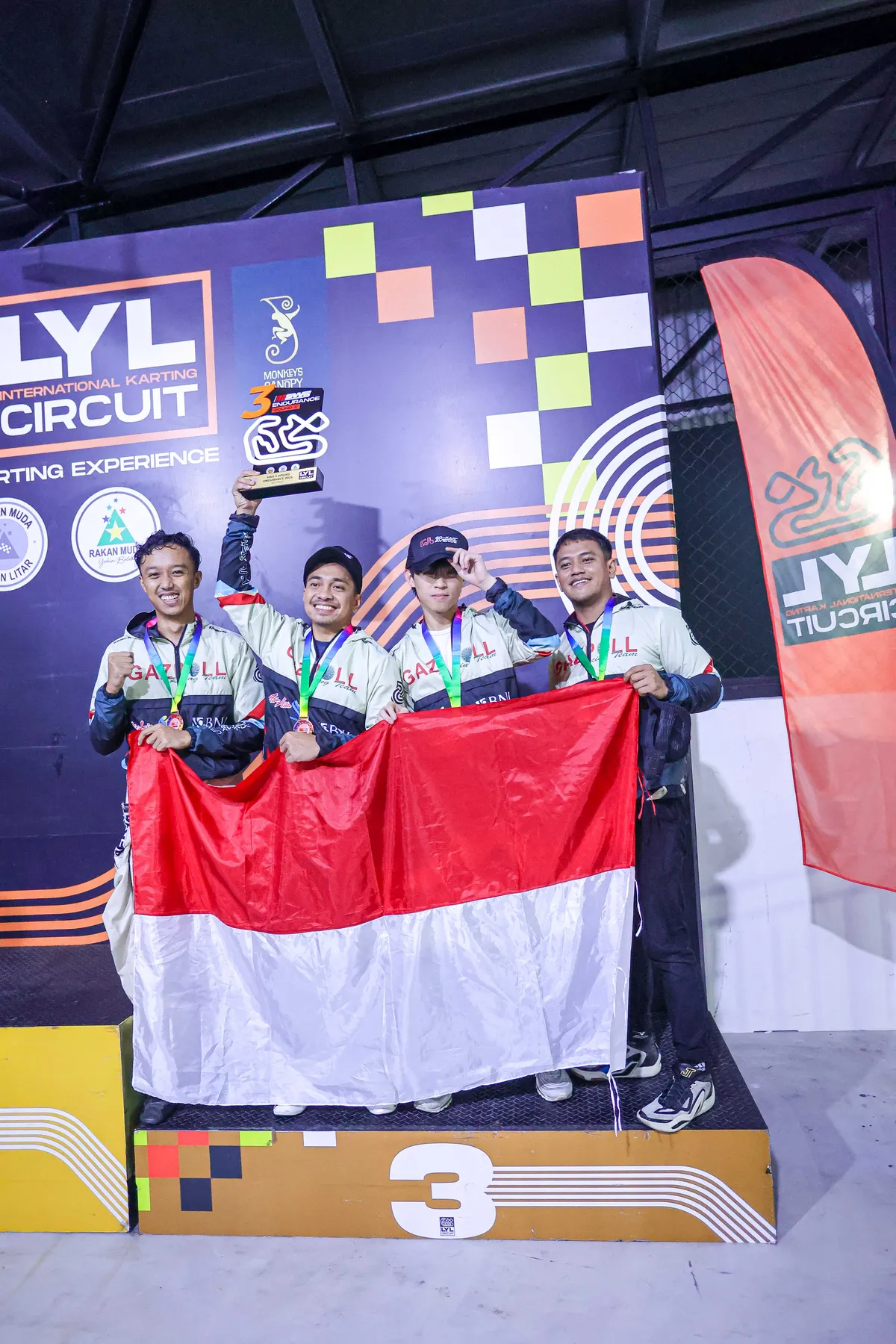 Faith Joshua Tzu on the podium holding the Indonesian flag at the LYL International Karting Circuit